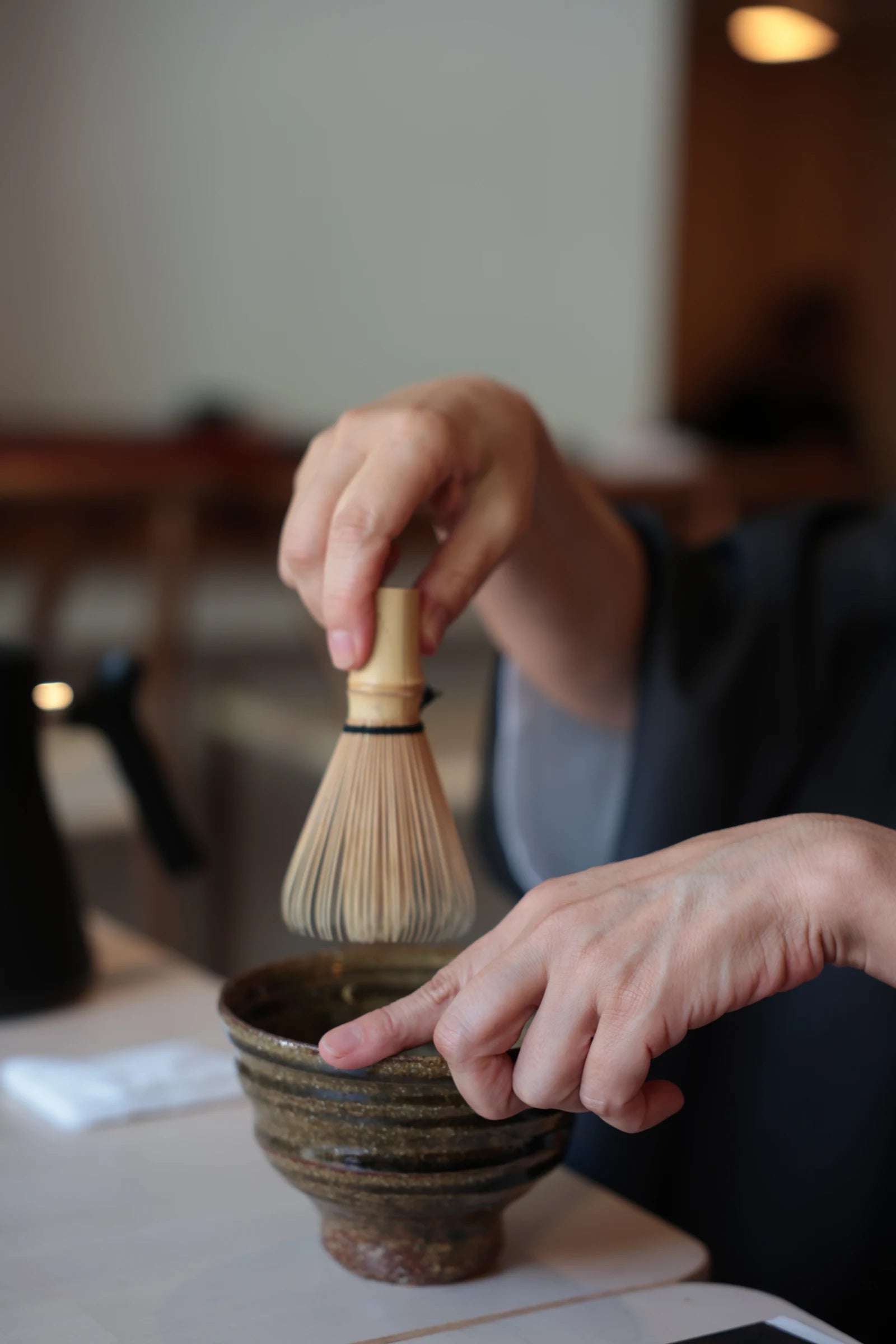 Whisking matcha in a ceramic bowl.