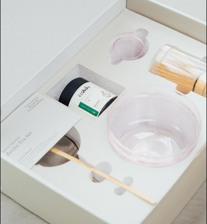 Isshiki x Hario pink matcha set packed in a white gift box: tin, glass bowl, bamboo whisk and scoop in a fitted tray