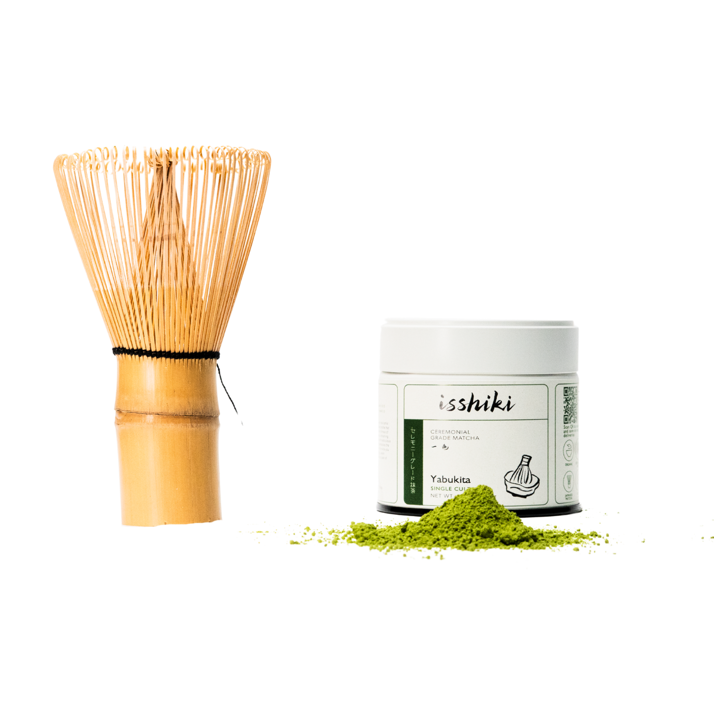Bamboo whisk beside white Isshiki Yabukita ceremonial matcha tin with a mound of vibrant green matcha powder