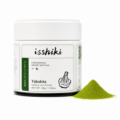 Isshiki Yabukita ceremonial matcha tin beside vibrant green matcha powder on white